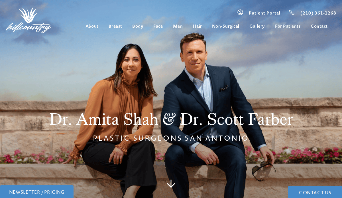 Two doctors, a woman and a man, sit outdoors on a stone bench in business attire, smiling at the camera. Text reads, “Dr. Amita Shah & Dr. Scott Farber, Plastic Surgeons San Antonio.”.