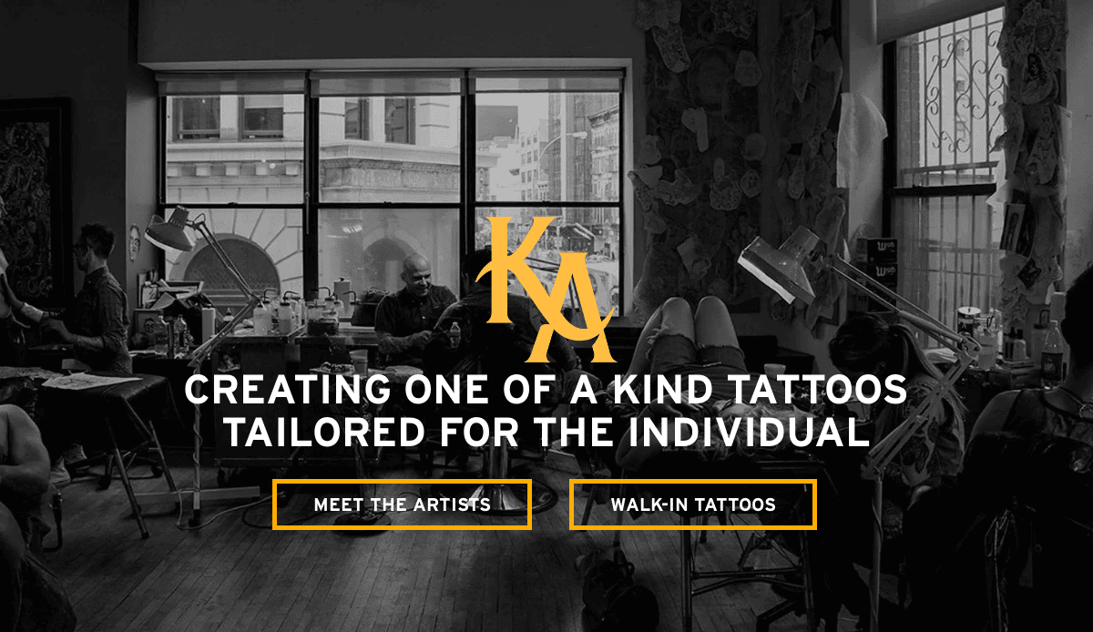 Black-and-white photo of a tattoo studio with artists working on clients. Large windows let in natural light. Text reads, Creating one of a kind tattoos tailored for the individual, with buttons for Meet the Artists and Walk-In Tattoos.