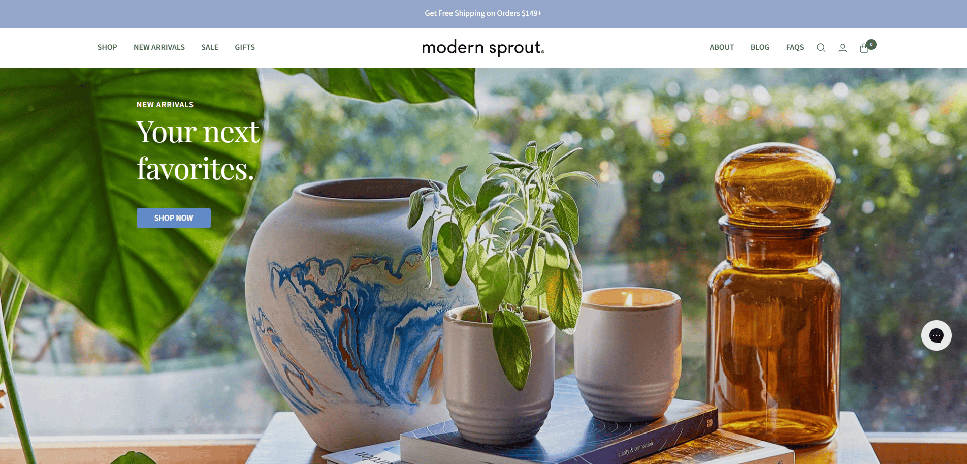 A colorful marbled vase, potted plant, two candles, and amber glass jar sit on stacked books by a window with greenery outside. A banner reads, “Your next favorites. Shop Now.”.