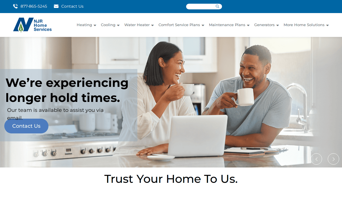 A smiling couple sits at a kitchen counter with coffee mugs and a laptop. Overlay text reads, “We’re experiencing longer hold times. Our team is available to assist you via email.” NJR Home Services branding is at the top.