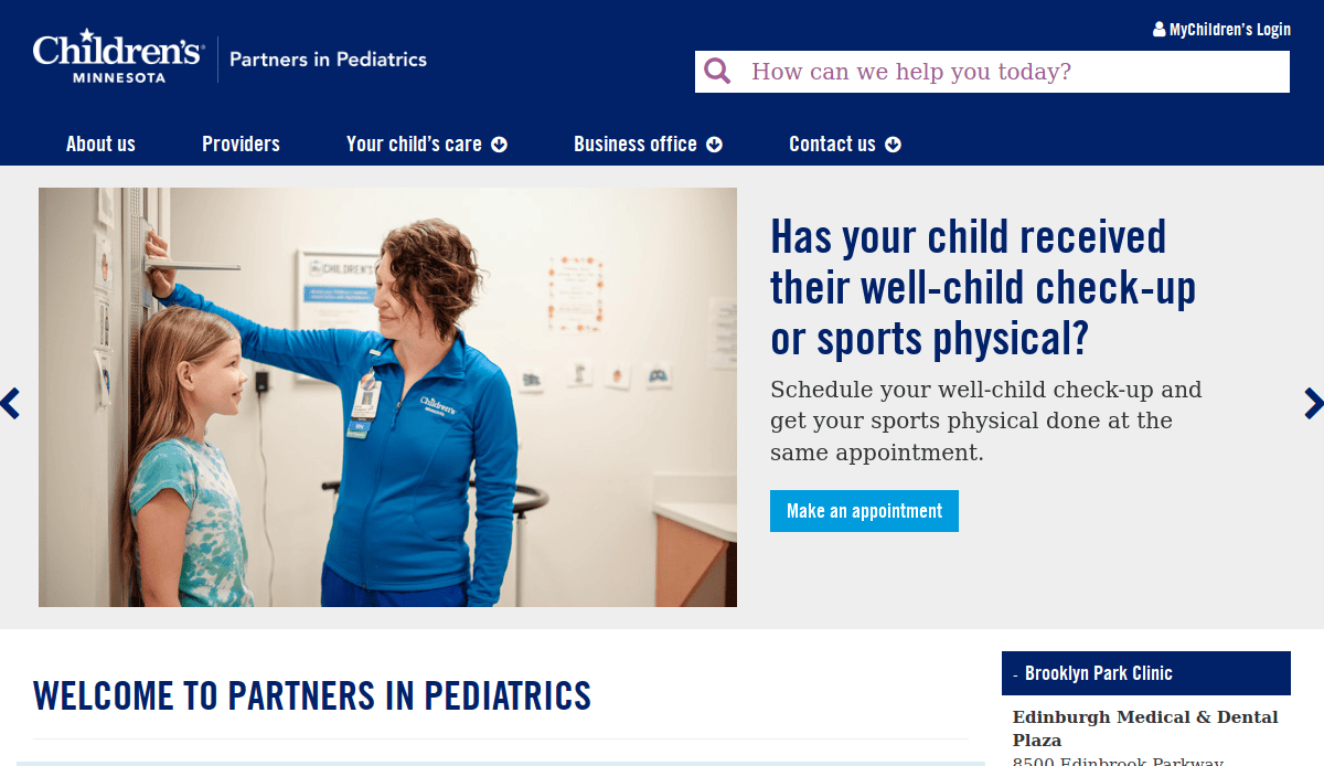 A female healthcare provider in blue scrubs measures the height of a smiling young girl against a wall in a medical office at Childrens Minnesota, promoting well-child check-ups and sports physicals.