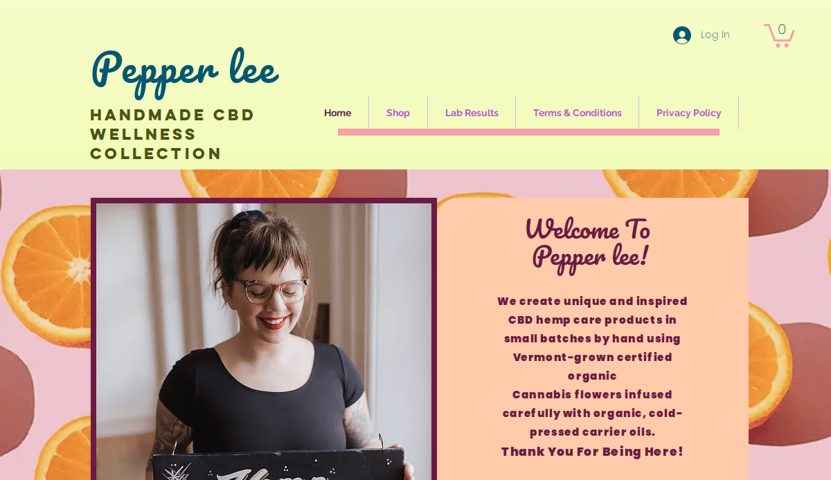 Screenshot of the Pepper Lee CBD website homepage, featuring a smiling person with glasses and tattoos holding a chalkboard sign, surrounded by orange slices, and text about handmade CBD wellness products.