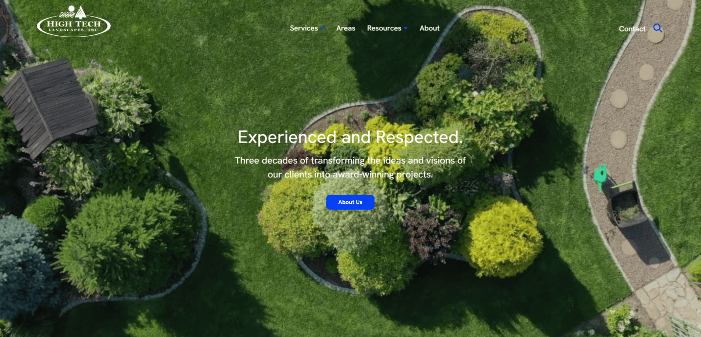 Aerial view of a landscaped garden with green grass, shrubs, and curved garden beds; website overlay text reads Experienced in Lawn Care with navigation and a blue About Us button.