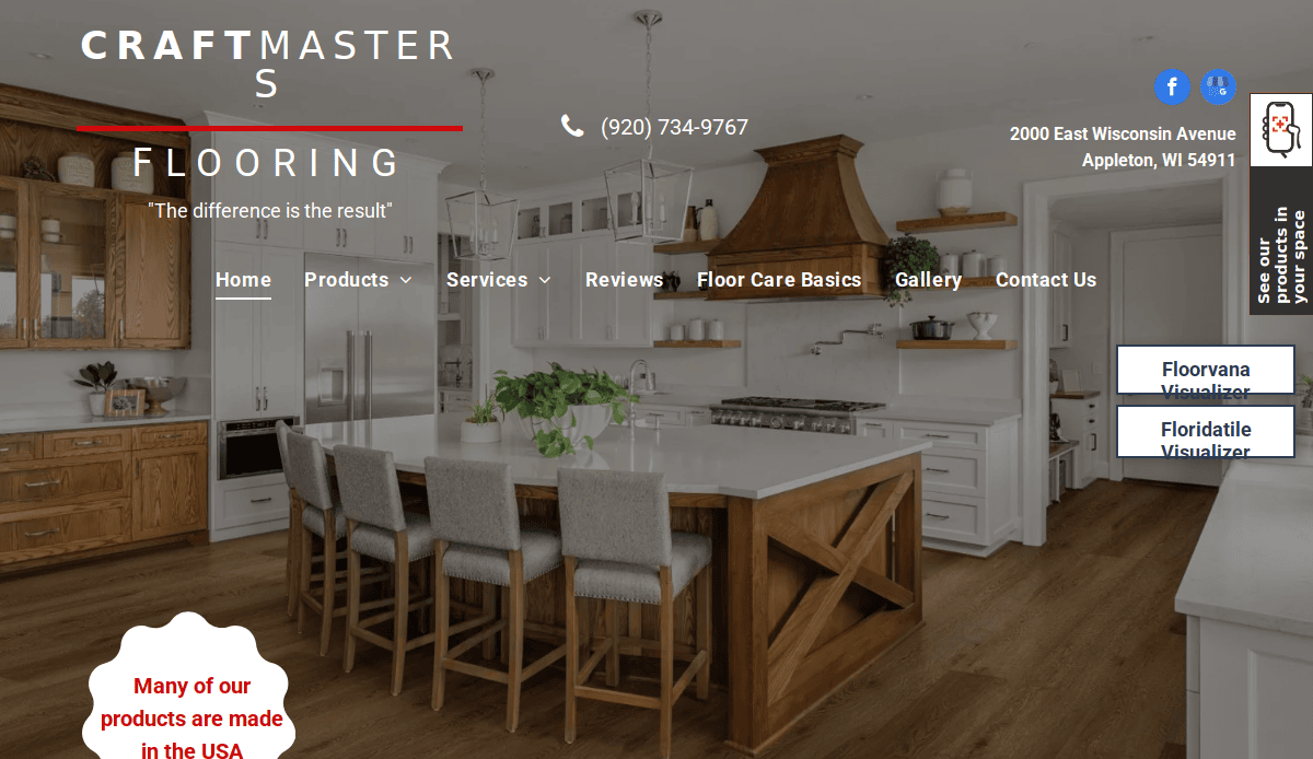 Spacious modern kitchen with wooden cabinets, white countertops, and a large island with stools. Craftmaster Flooring’s professional flooring website header and navigation menu overlay the image. Contact info and location are visible.