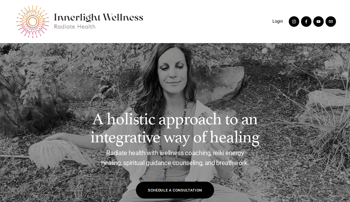 A woman sits cross-legged outdoors with eyes closed, holding a feather and smiling peacefully. Text overlays read: “A holistic approach to an integrative way of healing.” Wellness website navigation and logo appear at the top.