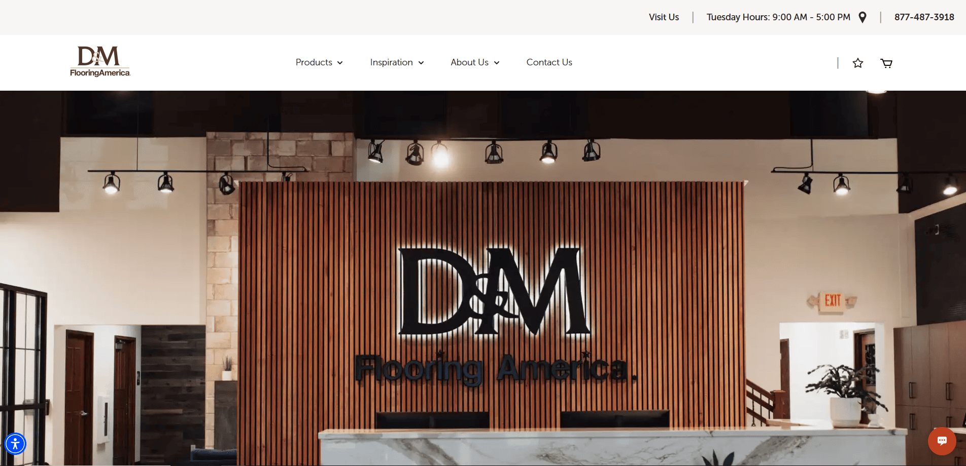Reception area of D&M Flooring America with a large illuminated company logo on a wooden slat wall, modern hanging lights, and a marble counter in front—an inspiring space for any professional flooring website design.