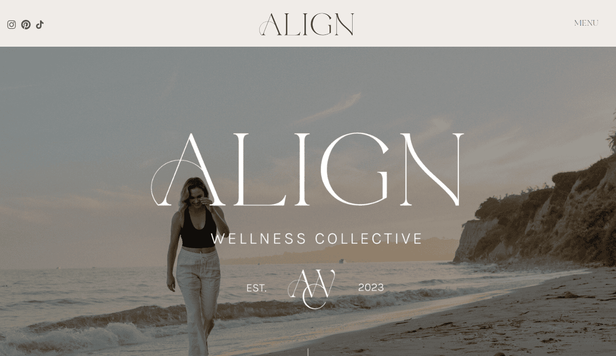 A woman walks along a beach at sunset with cliffs and trees in the background. ALIGN Wellness Collective and Est. 2023 are overlaid, reflecting holistic web design for a wellness website. Social media icons appear at the top left.