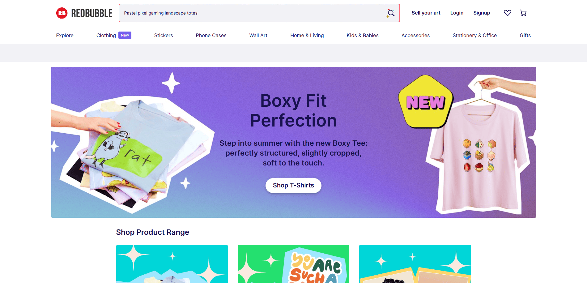 Screenshot of Redbubble’s homepage featuring a banner for the new Boxy Fit T-shirt, with a folded green shirt reading rat and a pink shirt with cartoon fruit, plus navigation links and a search bar at the top.