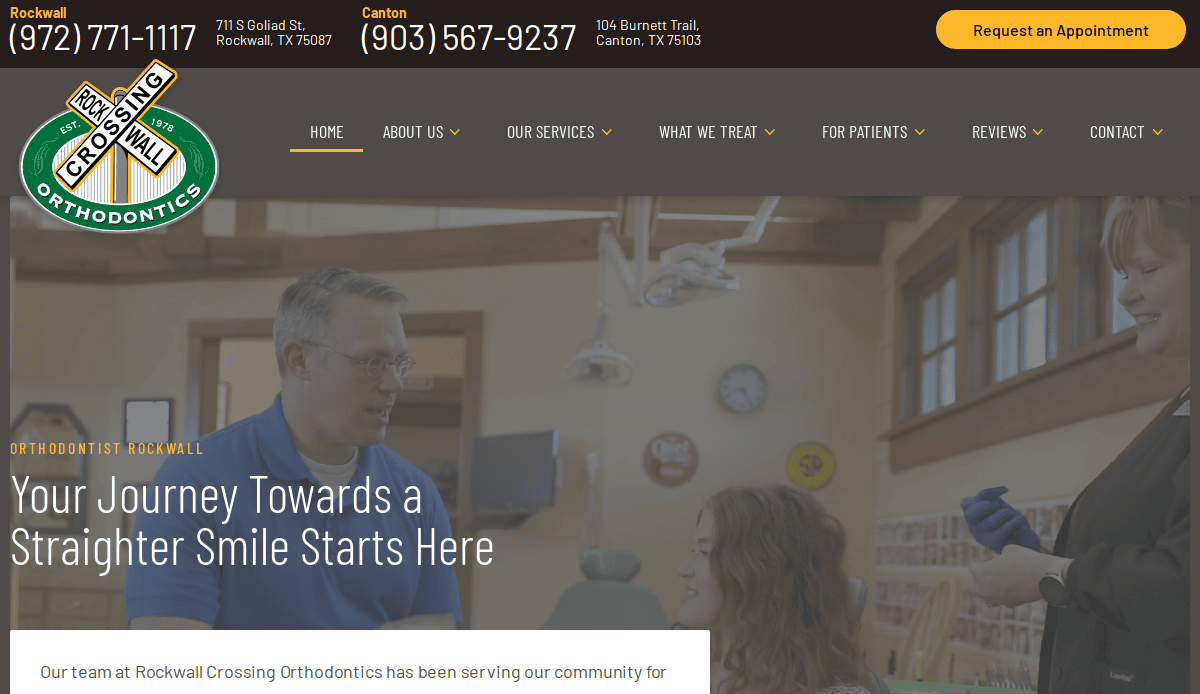 An orthodontist in a blue shirt talks to a young patient in a dental clinic, while an assistant prepares dental tools nearby. The clinic’s logo and contact information are displayed at the top of the website.