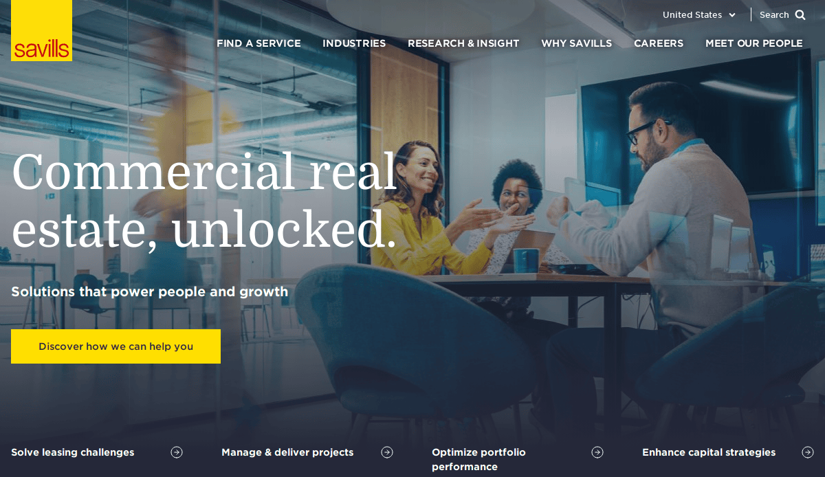 Group of four professionals meeting at a conference table, smiling and discussing in a modern office. Text overlay reads, Commercial real estate, unlocked. Solutions that power people and growth. Savills branding is visible.