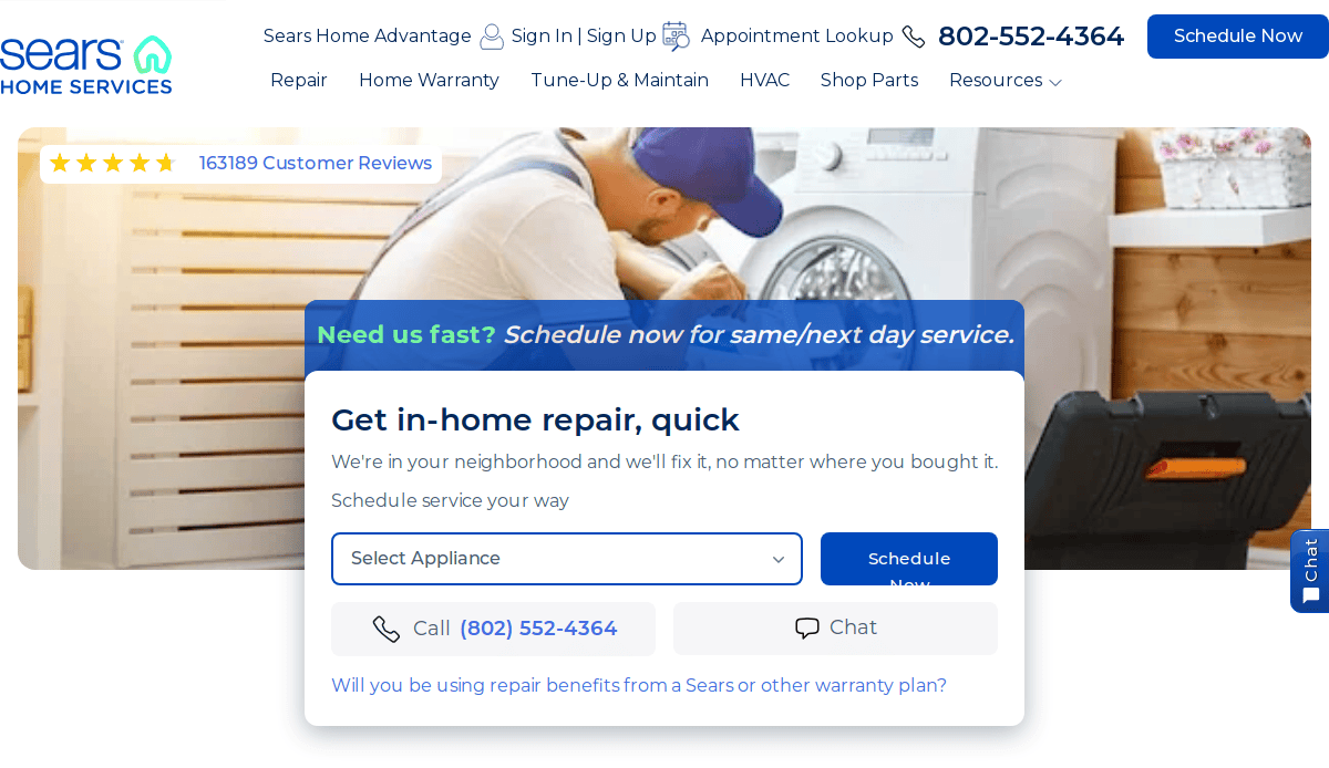 A technician in a cap repairs a washing machine in a bright laundry room. The Sears Home Services website displays options to schedule in-home repair, with a phone number and a blue Schedule Now button.