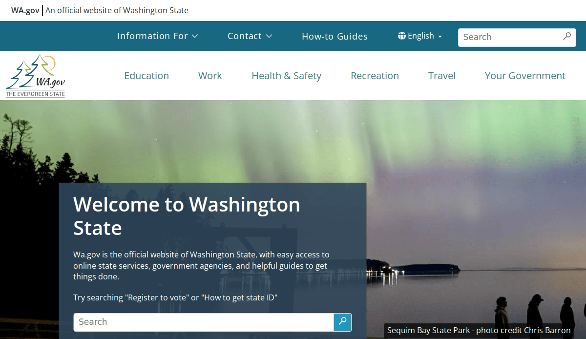 The homepage of the Washington State official website features a search bar and navigation menu, with a scenic photo of the northern lights over Sequim Bay State Park in the background.