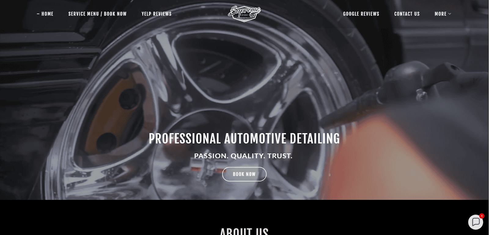 Close-up of a person cleaning a shiny car wheel with a tool. Overlay text reads Professional Automotive Detailing: Passion. Quality. Trust. with a Book Now button in the center. Website navigation is visible at the top.