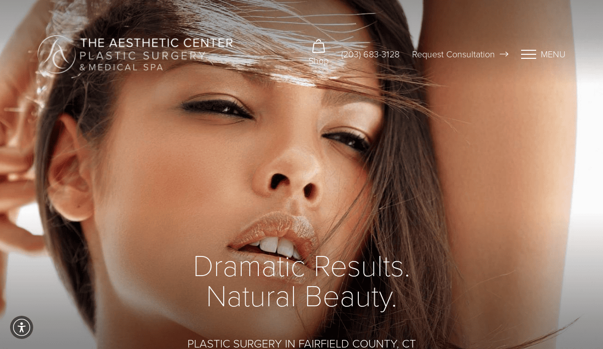 Close-up of a womans face with windblown hair, overlaid with text promoting The Aesthetic Center Plastic Surgery & Medical Spa, emphasizing dramatic results and natural beauty. Contact information and menu are visible at the top.