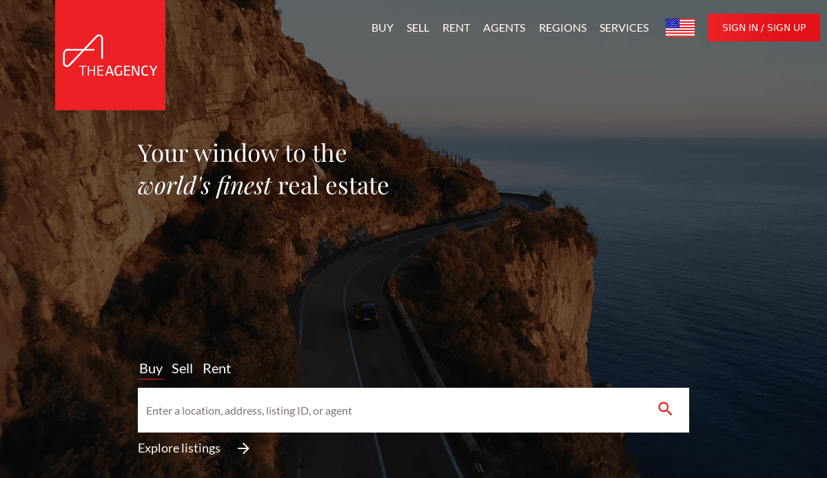 A coastal road winds along a rocky cliff at sunset, with a car driving by the sea. Overlay text reads: Your window to the world’s finest real estate and includes a property search bar. The Agency logo is at the top left.