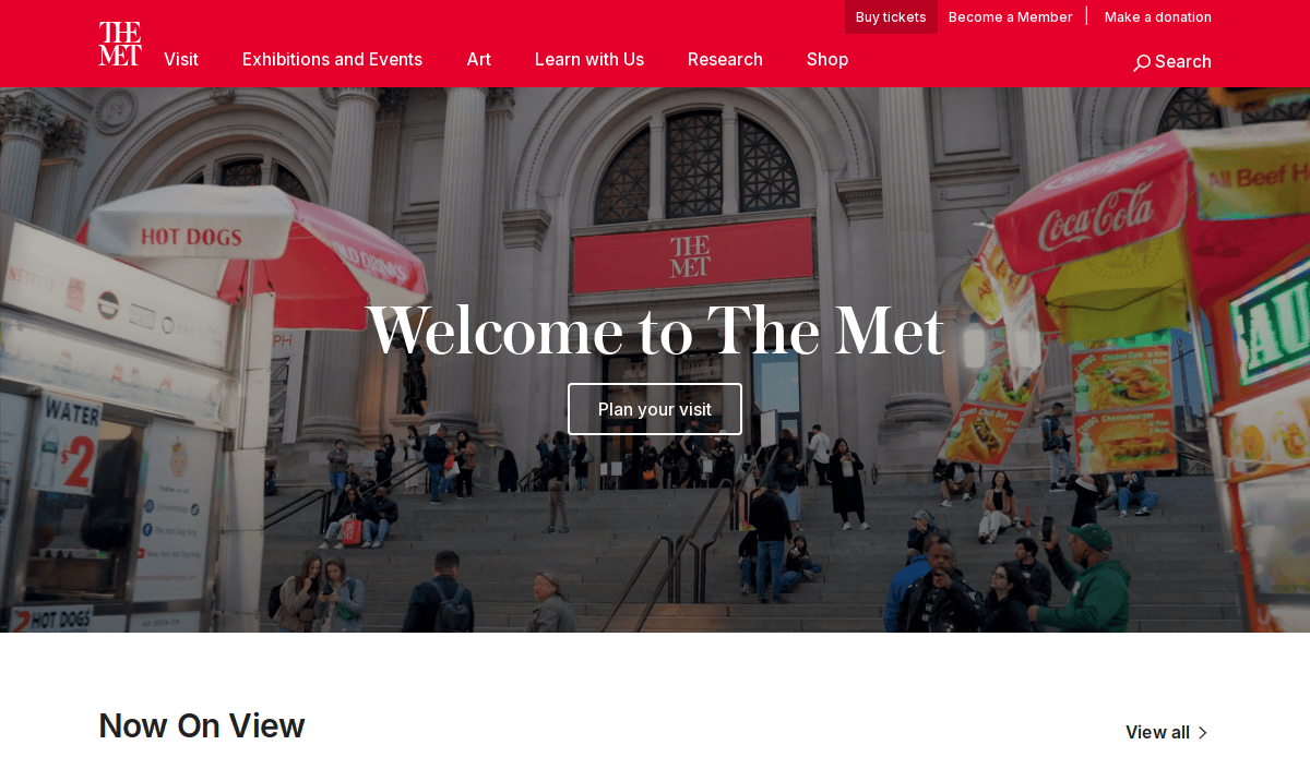 The entrance of The Met museum with people sitting on the steps, hot dog and food stands on both sides, and a large sign saying Welcome to The Met overlaid in the center.