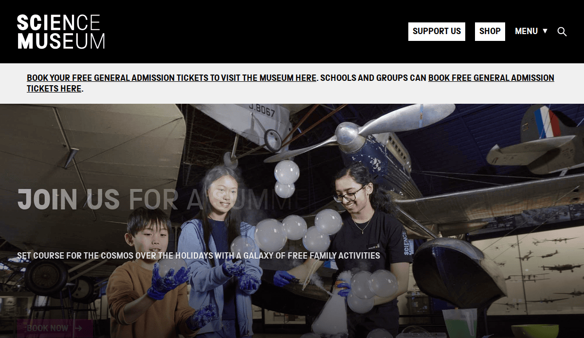 Three children and an adult play with balloons under hanging aircraft at a science museum. Text on the screen promotes free admission tickets and family activities for the holidays.