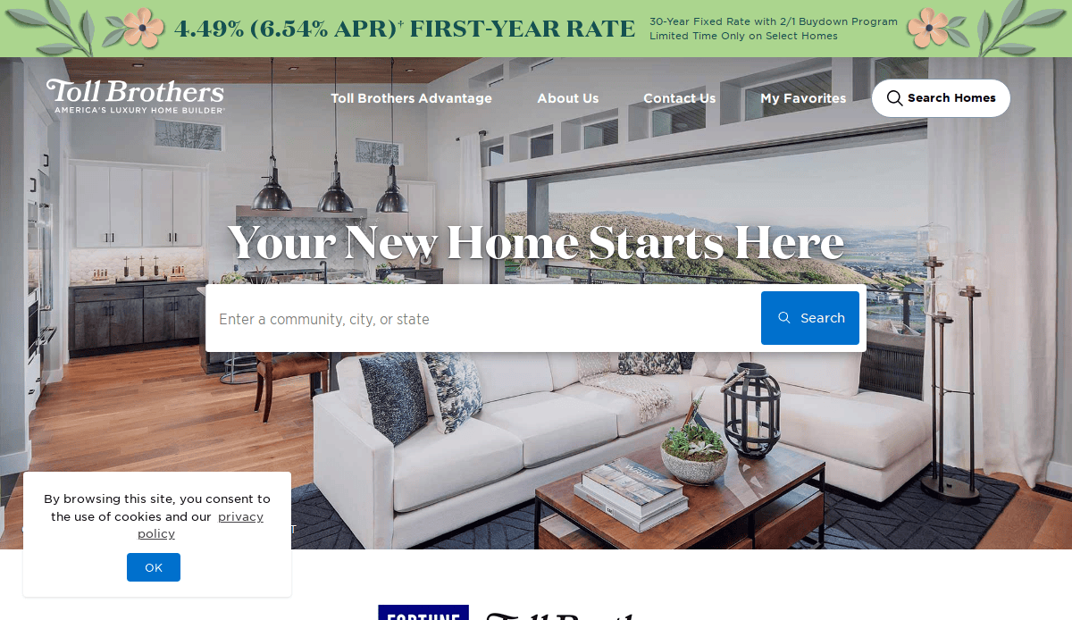 A modern, bright living room with large windows and contemporary furniture is featured on the Toll Brothers website, which has a search bar for finding new homes and banners advertising home loan rates.