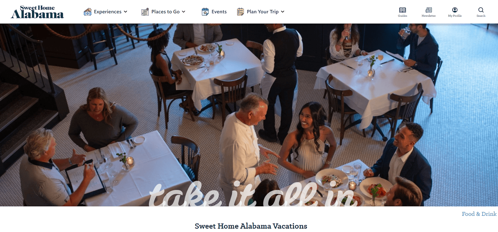 A restaurant scene with people dining at tables, enjoying food and conversation. A server hands a plate to a smiling woman in the center. The atmosphere is lively and welcoming, with soft lighting and elegantly set tables.