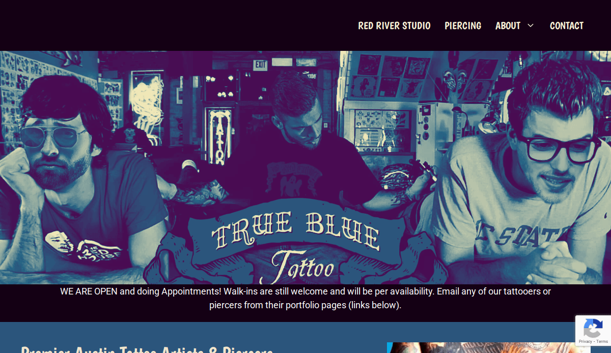 Three people with tattoos and sunglasses sit together in a tattoo studio with True Blue Tattoo text overlaid. The background includes tattoo designs, signs, and a neon light.