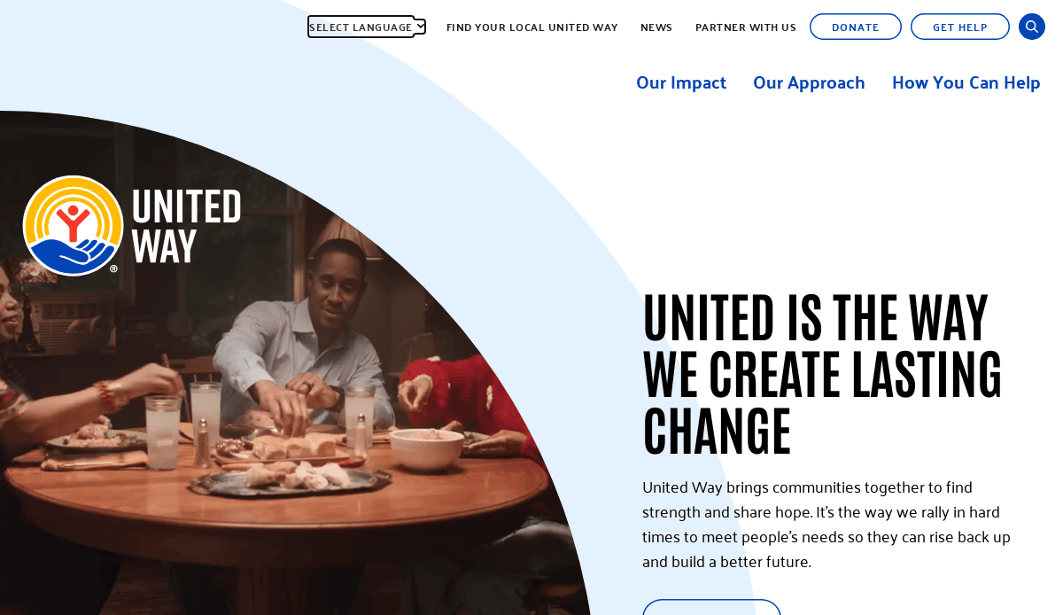 A diverse group of people share a meal around a table. The United Way logo appears on the left, and large text on the right reads, “United is the way we create lasting change.” Additional navigation options are at the top.