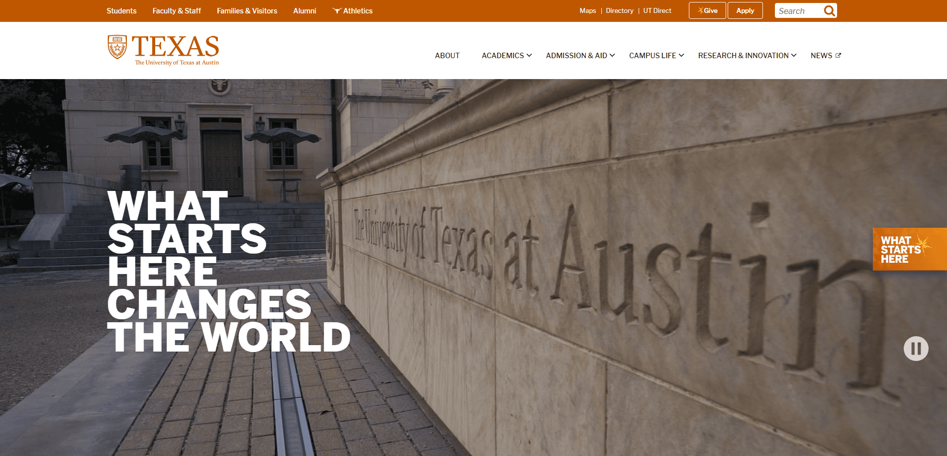 The University of Texas at Austin campus entrance with large engraved stone displaying the university’s name; bold white text reads, “What starts here changes the world.”.