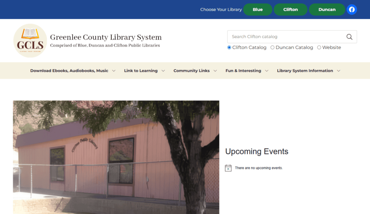 Screenshot of the Greenlee County Library System website showing a pink-walled building with a tree in front, plus contact info, library hours, and an upcoming events section noting there are no upcoming events.