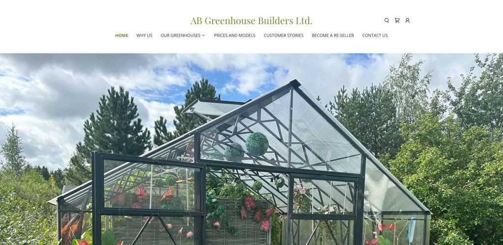 A greenhouse with open doors and plants inside, located outdoors surrounded by trees under a partly cloudy sky. The website header reads AB Greenhouse Builders Ltd. with navigation links.