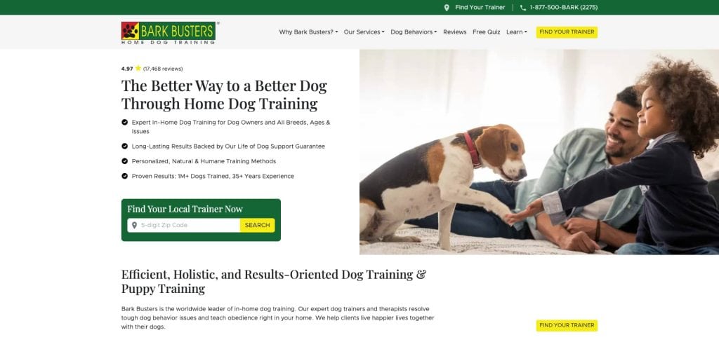 A woman sits on a couch inside a bright living room, gently holding a dog’s paw. Bark Busters branding and information about home dog training and services are visible on the website.