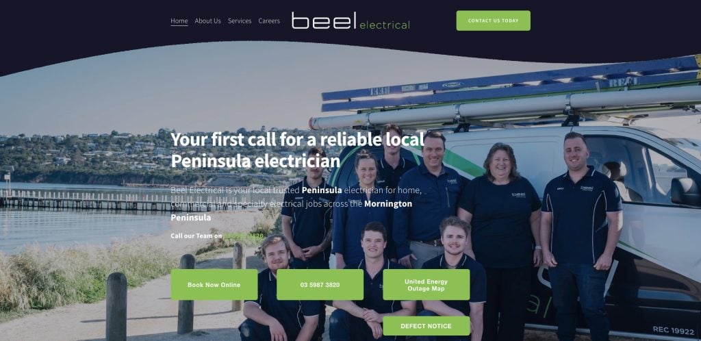 A group of seven people in navy blue uniforms pose in front of a van with ladders on the roof, near a body of water and wooden pier. The website is for Beel Electrical, promoting local electrician services.