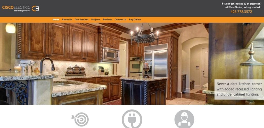 A modern kitchen with wooden cabinets, stainless steel appliances, granite countertops, a chandelier, and under cabinet lighting. Text overlay promotes kitchen lighting upgrades by Cisco Electric.