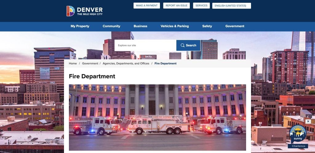 Screenshot of the Denver city government website’s Fire Department page, featuring a banner image of fire trucks with flashing lights parked in front of a large government building at dusk.