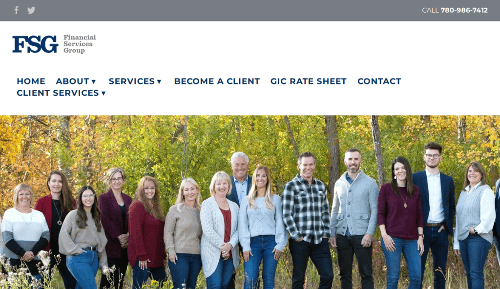 A group of thirteen people, both men and women, stand outdoors in front of autumn trees, smiling at the camera. They appear to be colleagues posing for a professional team photo.