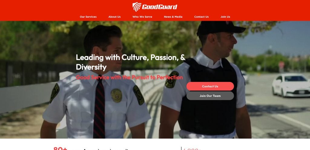 Two uniformed security guards walk outdoors on a sunny day. The website banner features the GoodGuard logo, navigation menu, and text promoting culture, passion, diversity, and career opportunities.