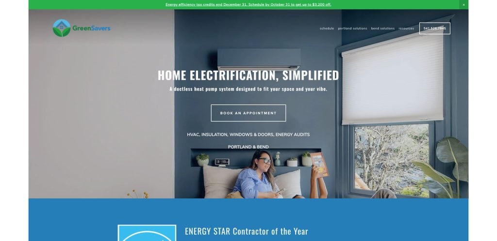 Screenshot of the GreenSavers website featuring a woman reading on a couch beneath a wall-mounted heat pump. The text promotes home electrification with a Book an Appointment button and navigation menu at the top.