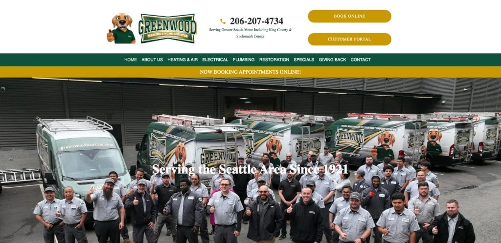A large group of uniformed Greenwood Heating & Home Services employees pose in front of several branded company vans parked outside a building, with the company logo and contact information above.