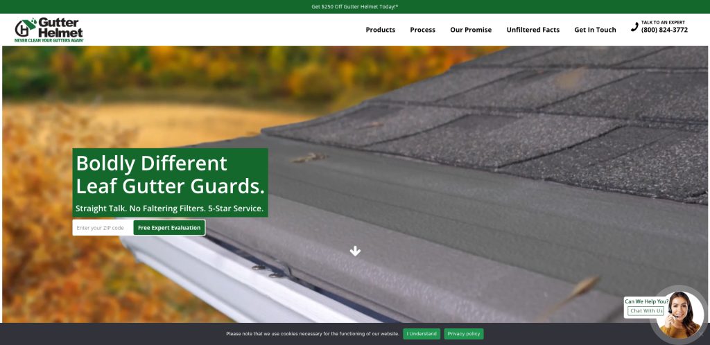 Close-up of a house roof with Gutter Helmet leaf gutter guards installed. Text overlay reads, Boldly Different Leaf Gutter Guards. with a button for a free expert evaluation. Autumn foliage is blurred in the background.