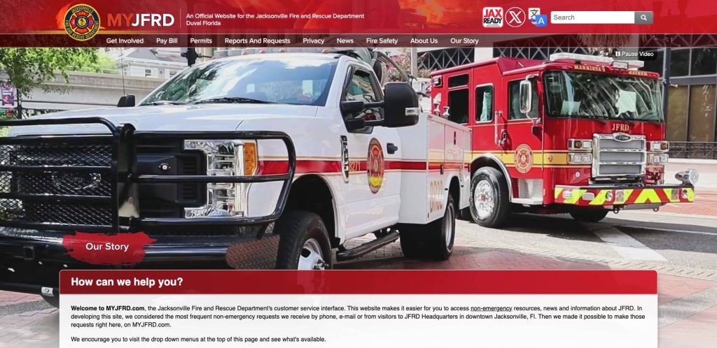 A white Jacksonville Fire and Rescue Department (JFRD) truck and a red fire engine are parked outside a building. The JFRD website banner and navigation menu are visible at the top of the image.