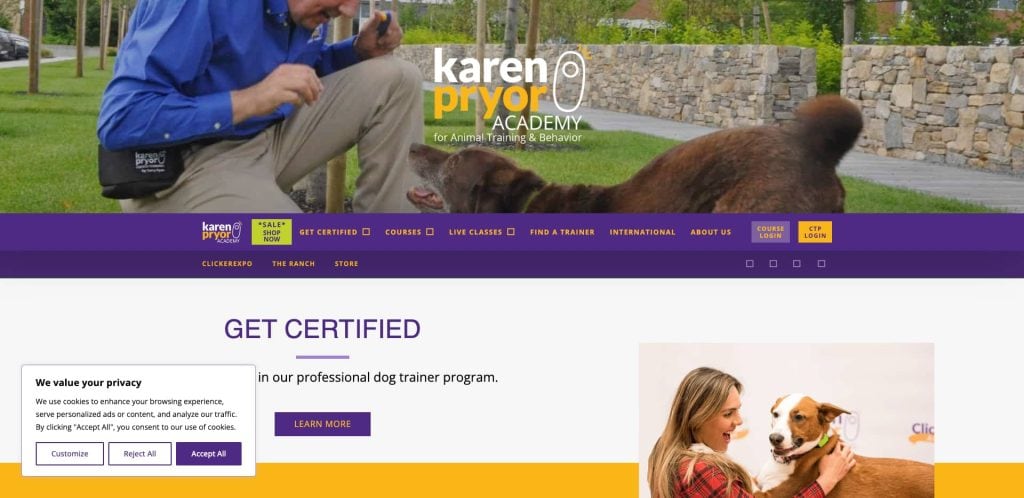 Screenshot of the Karen Pryor Academy website showing a man training a dog outdoors and a woman holding a dog indoors, with text offering information about dog trainer certification.