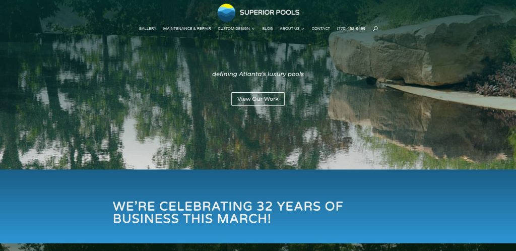 Website homepage for Superior Pools, featuring a serene pool with reflections of trees, a “View Our Work” button, and a banner announcing 32 years of business this March. Navigation menu is visible at the top.