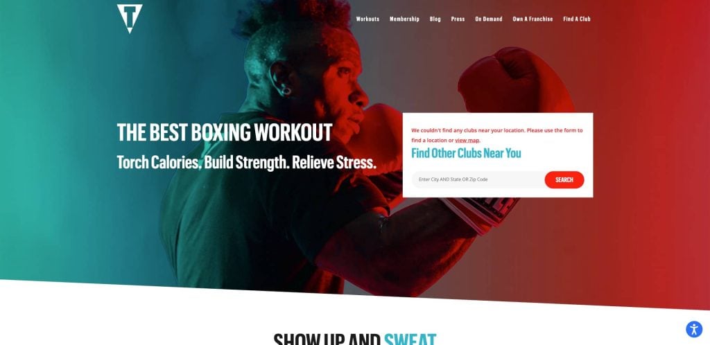 A boxer with a mohawk throws a punch against a red and teal background. The text reads, The Best Boxing Workout. Torch Calories. Build Strength. Relieve Stress. Theres a location search box and a notification about club availability.