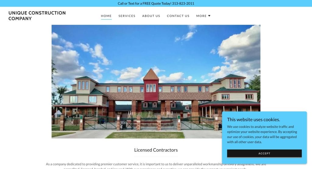 A large, modern brick building with multiple peaked roofs, red window frames, and fenced entrances under a partly cloudy sky, featured on a contractor’s website homepage.