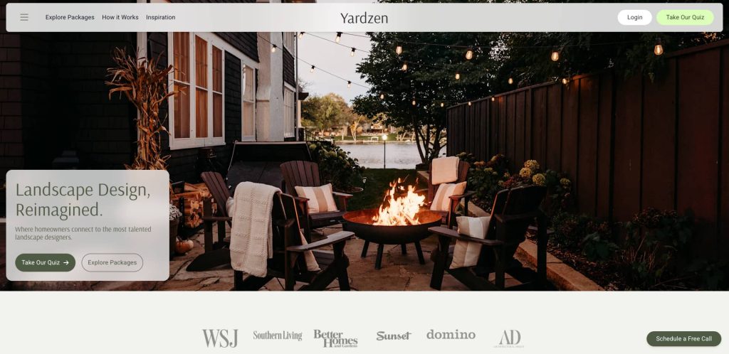 Cozy backyard patio with chairs, blankets, and a fire pit, set near a lake at dusk. The scene is inviting and tranquil, with string lights and greenery creating a warm, relaxing atmosphere.