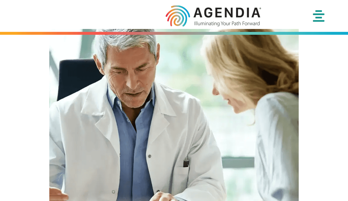 A male doctor in a white coat discusses medical documents with a woman in an office setting. The Agendia logo and tagline, Illuminating Your Path Forward, highlight innovative Biotech website design at the top of the image.