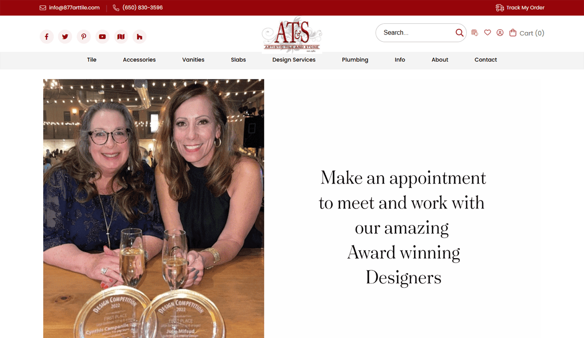 Two smiling women holding champagne glasses and sitting at a table with design award plaques; text beside them reads: Make an appointment to meet our amazing, award-winning designers, experts in lead generation and website security.