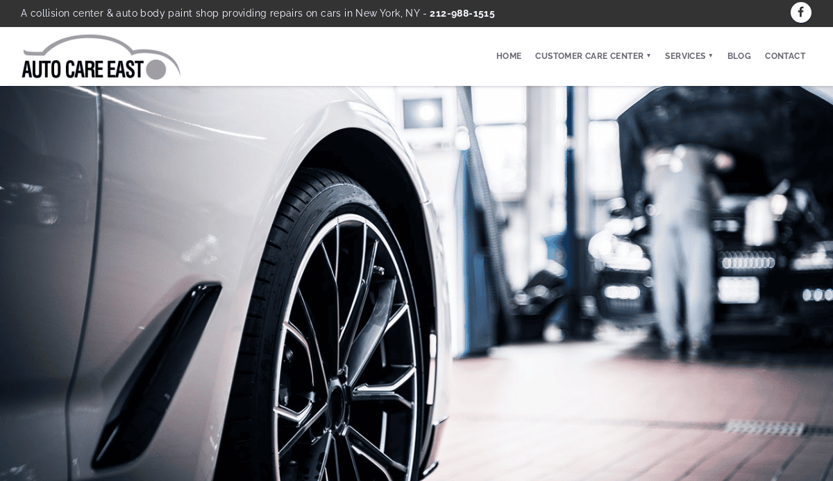 Close-up of a silver car’s wheel in a service shop, with a mechanic working on another car in the blurred background. Auto Care East branding and navigation menu highlight a professional car mechanic website design.