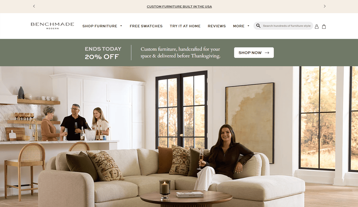 A woman sits on a cream sectional sofa in a modern living room while three people chat near the kitchen island. Large windows let in natural light. A banner promotes 20% off and highlights ongoing maintenance for furniture website design.