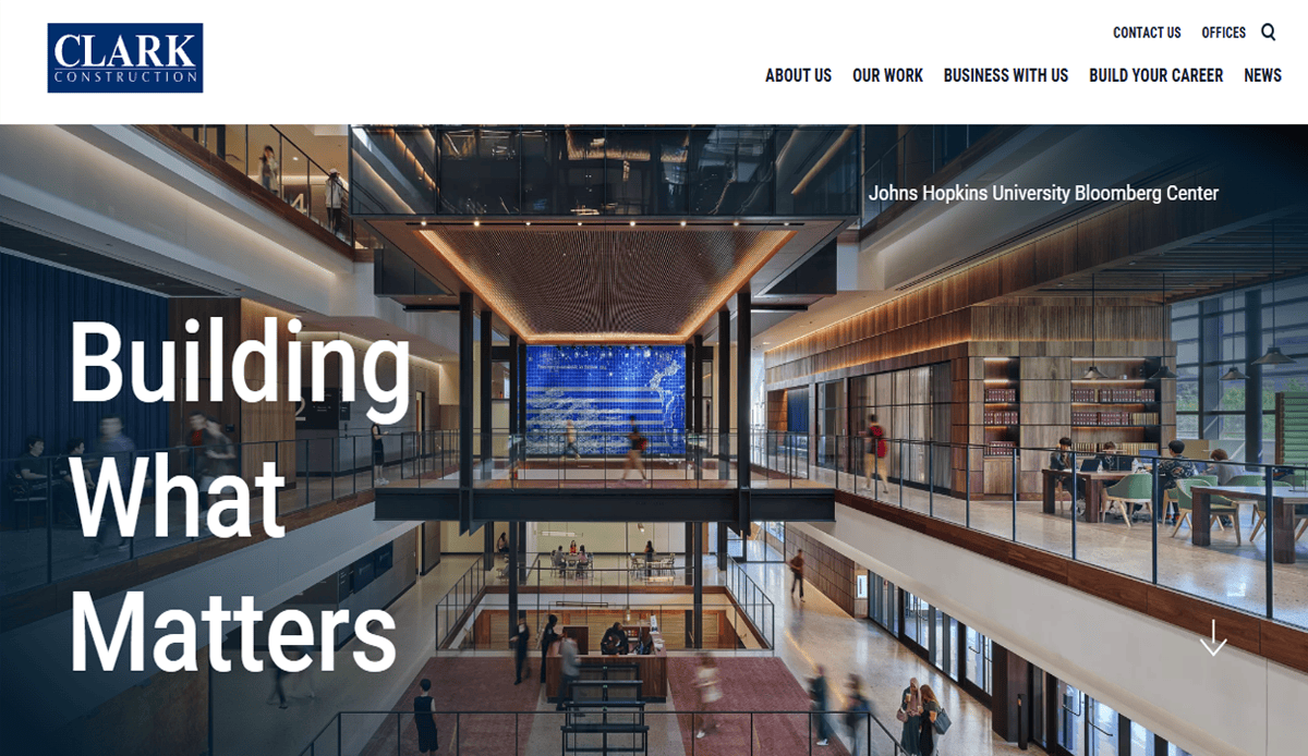 Clark Construction website homepage showcasing professional commercial construction at the Johns Hopkins University Bloomberg Center, featuring a modern, open interior with people working and “Building What Matters” overlaid on the left.