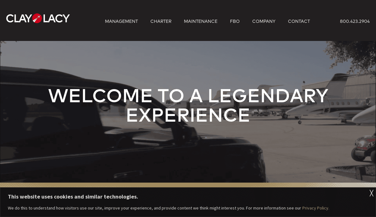 A black vehicle parked on an airport tarmac with several private jets in the background. The text WELCOME TO A LEGENDARY EXPERIENCE appears, showcasing Clay Lacy’s digital hangar and sleek aviation website design. The site navigation is visible at the top.