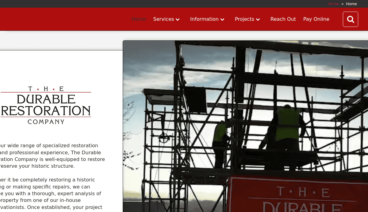 Two workers in safety vests stand on scaffolding during restoration work, silhouetted against the sky. To the left, The Durable Restoration Company logo and text are visible on a white panel, highlighting their expertise in masonry website design.